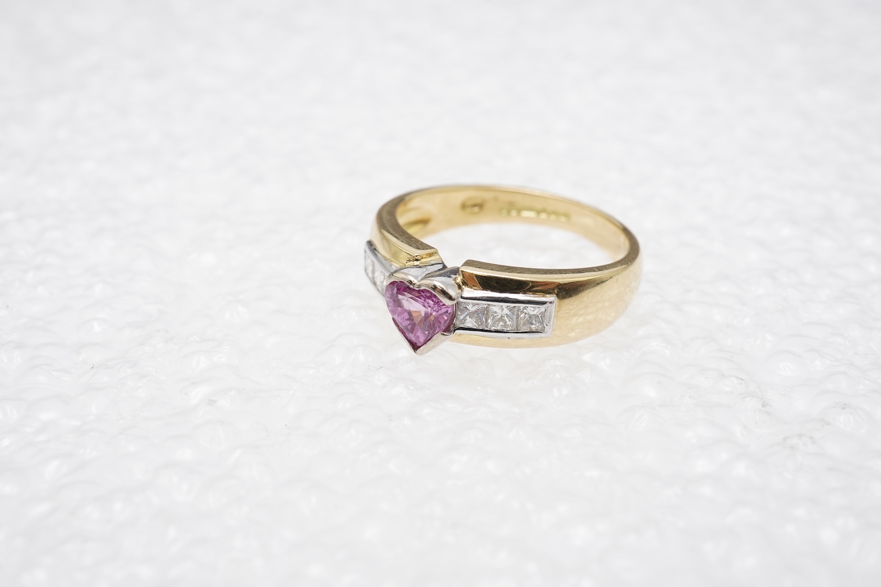 A pink sapphire and diamond ring